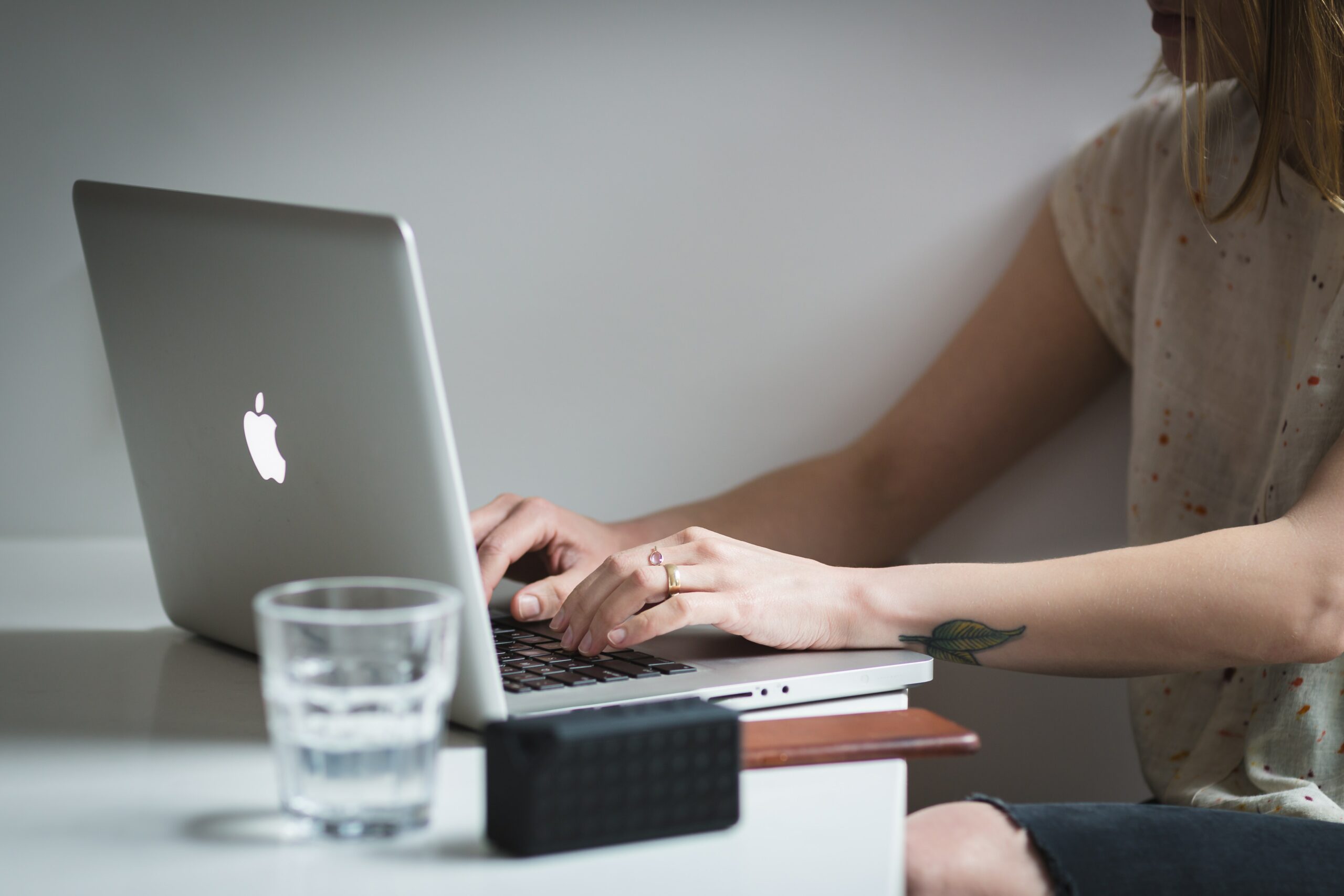 typing-on-laptop-with-a-glass-of-water